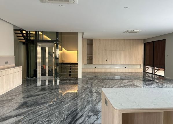 Large living room with marble flooring and a lift and staircase